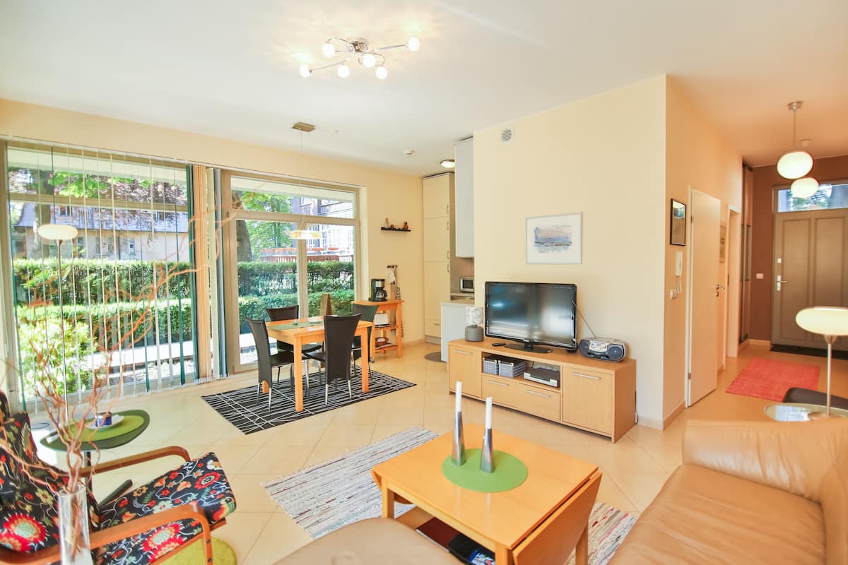 A modern living room with a TV, sofa, and dining area.