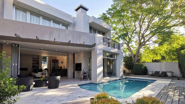 Uma casa moderna com piscina, área de estar externa e cozinha.