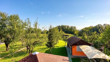 Ländliche Landschaft mit einem kleinen Haus, einer Wiese und Bäumen.