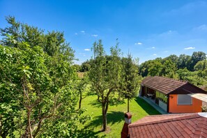 A house with a red roof, surrounded by lush green trees and grass.