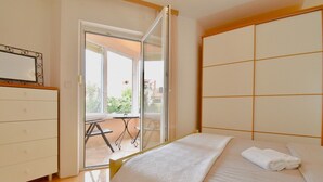 A bedroom with a bed, a dresser, and a sliding glass door leading to an outdoor area. - Lovely apartment few minutes from the beach (Štinjan)