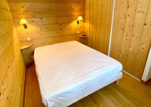 Simple, functional room with a single bed and two wall-mounted lamps.