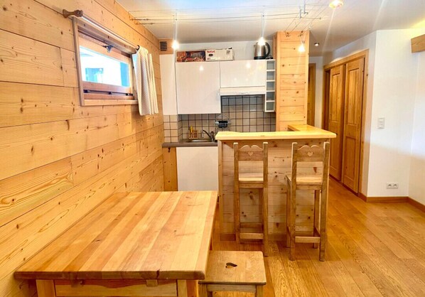 Kitchen area with a sink, cabinets, and a small table for dining.
