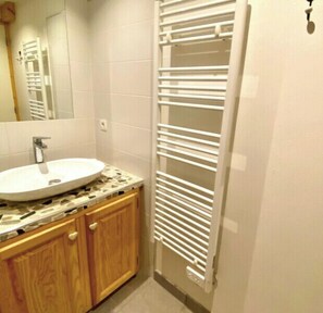 Bathroom features a sink, mirror, towel rack, and radiator.