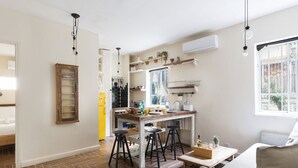 Eine moderne Küche mit einer Holztheke, Barhocker und einem Esstisch mit einer Platte voller Speisen und Getränke.