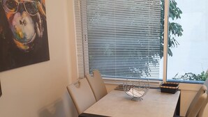 Een eethoek met een tafel, stoelen en een decoratief object op de tafel.