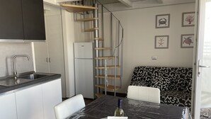 Ett modernt kök med en inbyggd diskho, ett kylskåp och en trappa i trä.