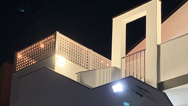 En byggnad med flera våningar och en modern arkitektonisk design, med en framträdande trappa och fönster som är upplysta.
