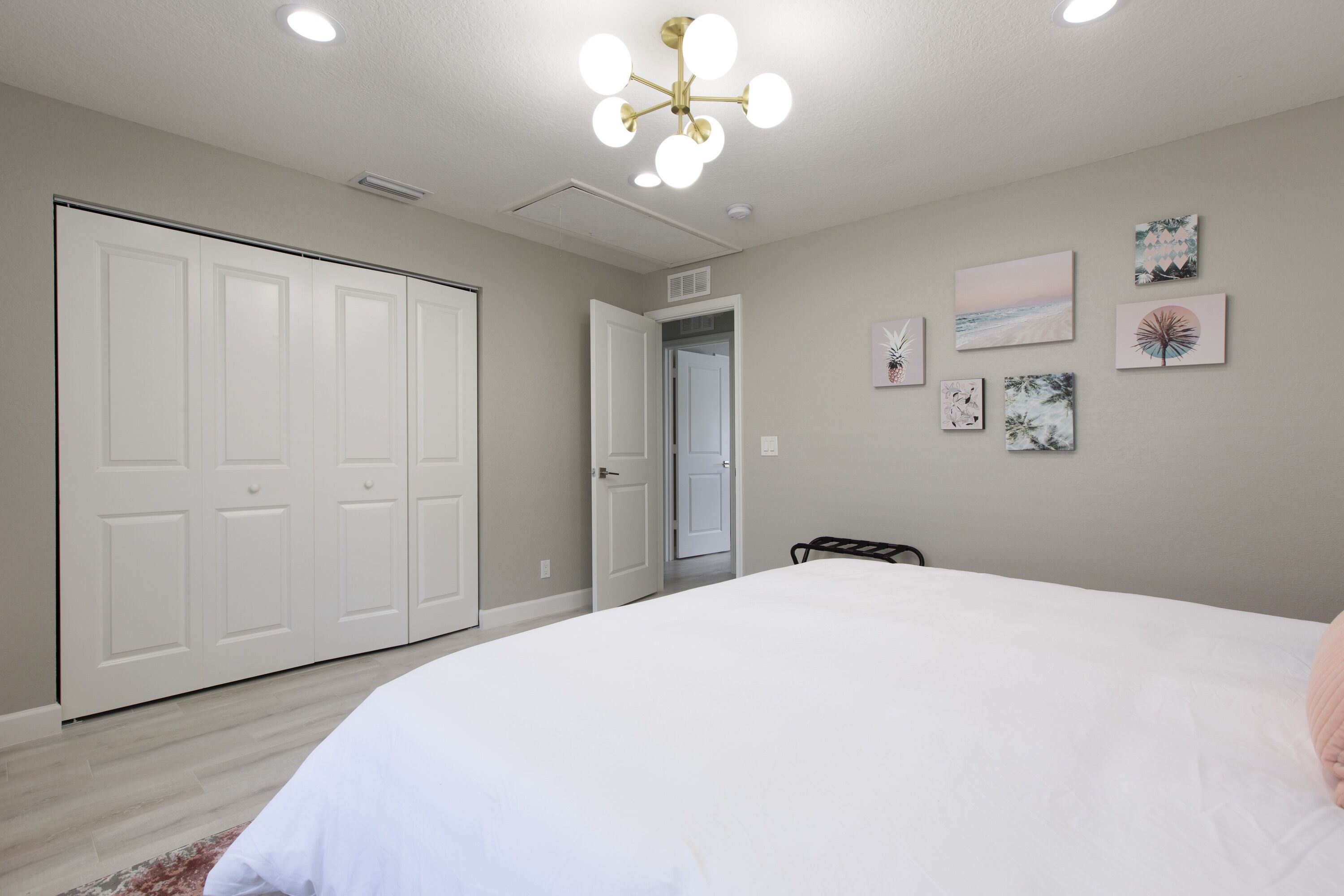 A bedroom with a large bed, a wardrobe, and a ceiling light fixture.