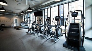 A gym with treadmills, elliptical machines, and a stair climber. - Downtown Indy Apartment w/ Balcony, Pool & Parking (Indianapolis)