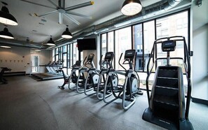Ein Fitnessstudio mit Laufbändern, Crosstrainern und einem Steiger.