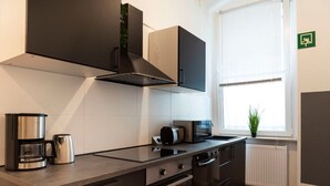 Une cuisine moderne équipée d’une cuisinière intégrée, d’une machine à café et d’un grille-pain.