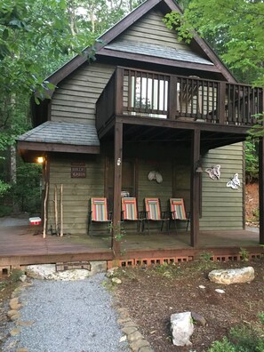 A cabin with a porch, outdoor seating, and a sign indicating it is a hikers' cabin.