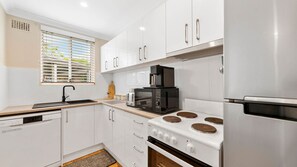 Enjoy cooking in this kitchen with sleek cabinetry, an oven, and a stainless steel refrigerator.