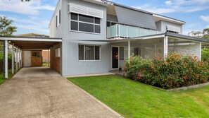 Stylish two-story home with a covered porch, large windows, and a beautifully maintained yard.
