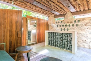 A wooden room with a stone wall, a woven ceiling, and a series of skull decorations. - Eco-Lifestyle Community with Magnificent Amenities  (Tulum)