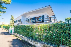 Ein modernes Gebäude mit Flachdach, großen Fenstern und einem Balkon.