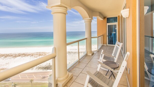 Un balcon avec vue sur la plage et l’océan.