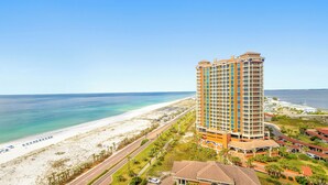 Ein Hochhaus-Hotel mit mehreren Balkonen mit Blick auf Strand und Meer.