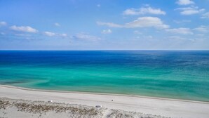 A beach with clear turquoise waters and a sandy shore.