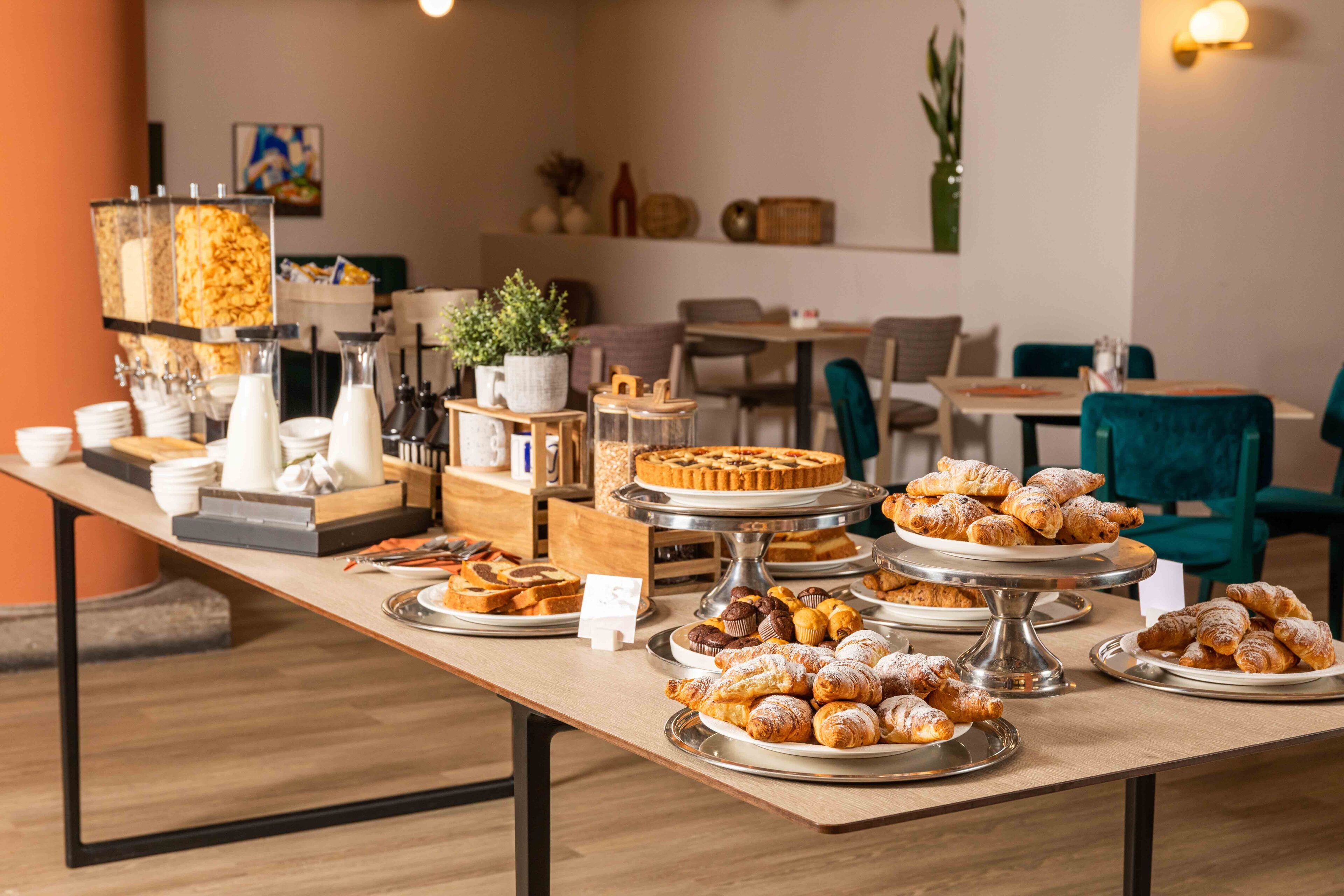 A buffet table with various pastries and a coffee station.