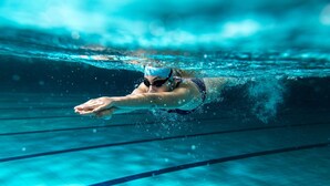 A swimmer in a pool with lane markings.