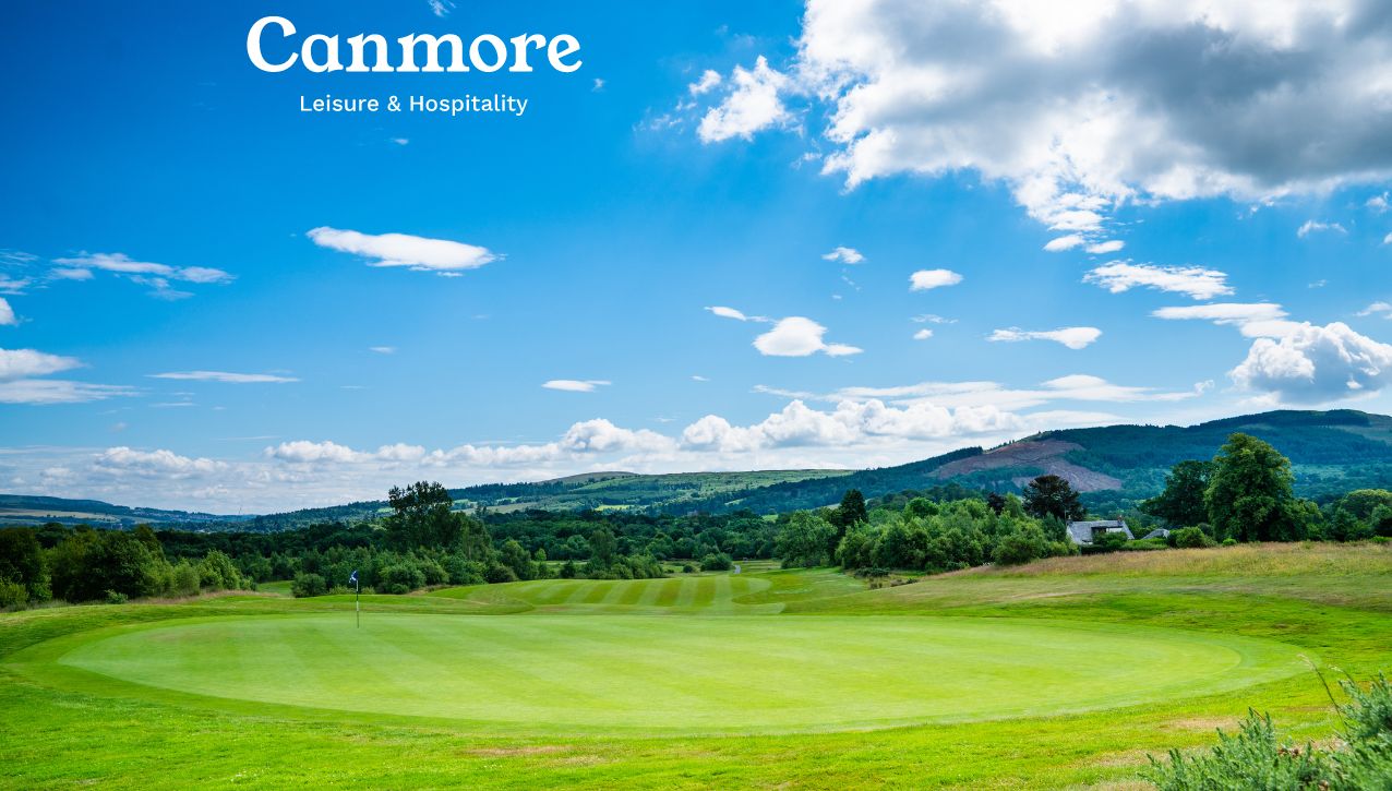 Un parcours de golf avec un ciel dégagé et des collines à l’horizon.