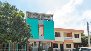 A building with a sign reading "Hostal Kumbaya" and a gated entrance. - Hostal Kumbaya (Santa Marta)