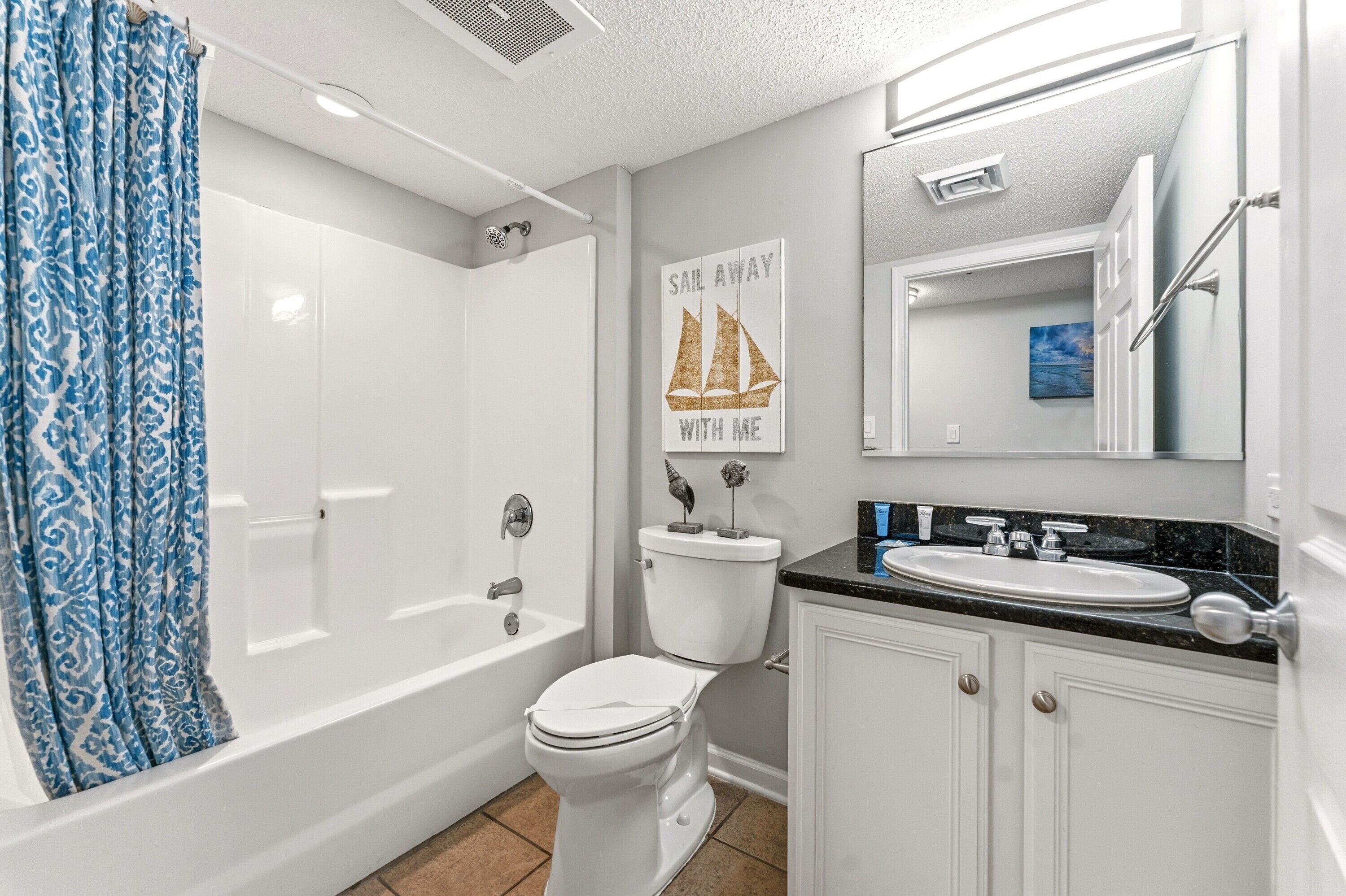 Un baño con bañera, inodoro, lavabo y espejo.