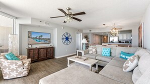 A living room with a sofa, coffee table, and a ceiling fan.