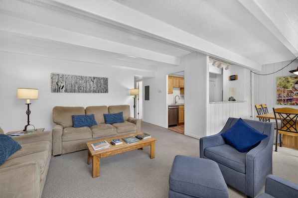 A living room with a sofa, armchairs, a coffee table, and a dining area with a table and chairs. - Vail/Lionshead 2-bedroom condo, walk to Ski Lifts (Vail)