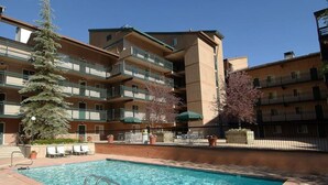 Une piscine entourée d’un immeuble à plusieurs étages doté de balcons.