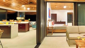 A modern interior with a wooden ceiling, a dining area, a living room with a sofa, and a visible bedroom. - 3BR Ocean & Mountain View Escape, Short Drive to the Beach! (Uvita)