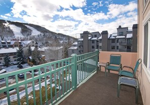 A balcony with a view of a snowy mountain and buildings.