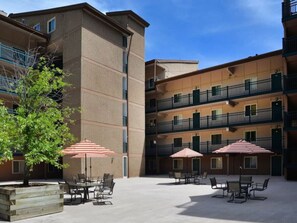 Guests can enjoy the tranquil courtyard with outdoor seating areas and shaded tables.
