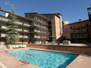 Guests can enjoy a refreshing swim in the pool surrounded by lush greenery and comfortable outdoor seating.