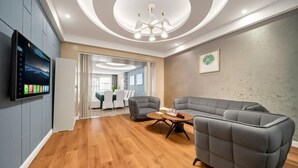 Een modern interieur met een hoekbank, een flatscreen televisie en een houten vloer.