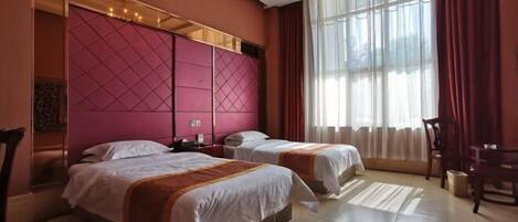 Habitación de hotel con dos camas, un ventanal con cortinas, un candelabro y una silla de madera.