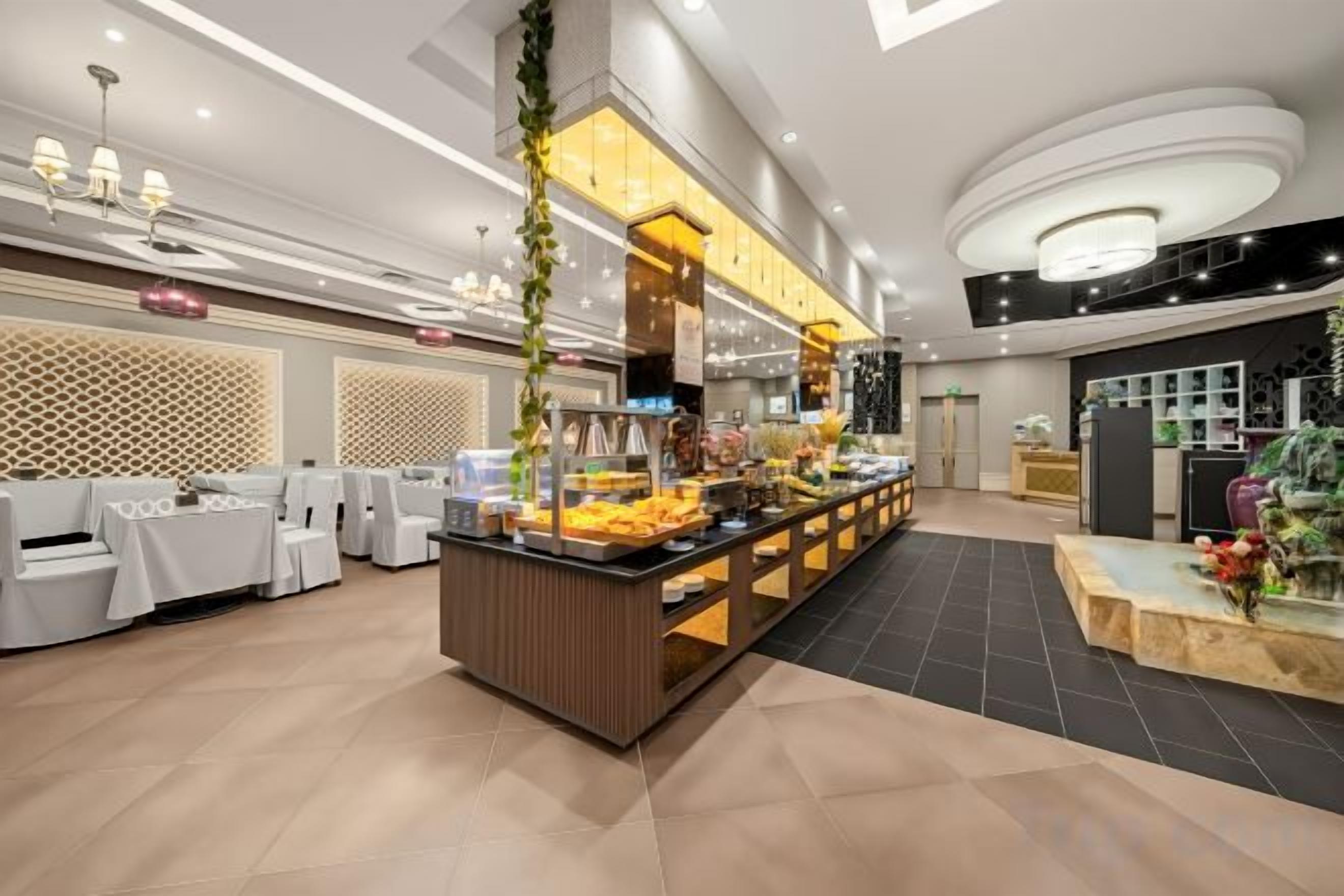 Un'area buffet con un'isola centrale per il servizio, disposizione dei posti a sedere e un design d'interni moderno.