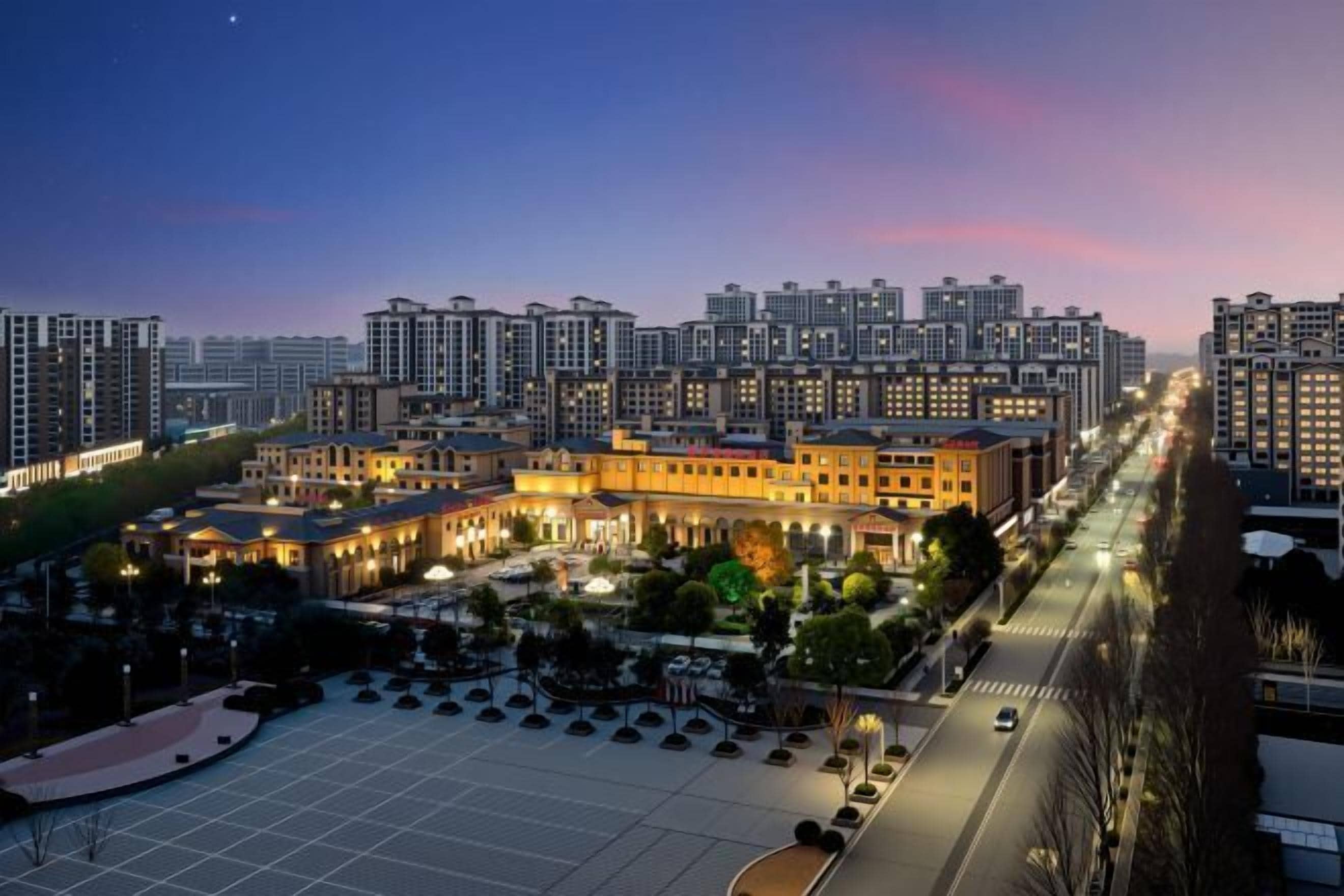 A high-rise hotel complex with multiple buildings, a central courtyard, and a well-lit street.