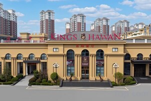 A hotel with a prominent sign, a main entrance, and a parking area.