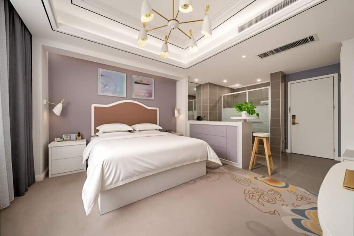 Une chambre moderne avec un grand lit, des tables de chevet, un bureau et une chaise.