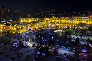 A hotel with multiple floors, a central courtyard, and a parking area.