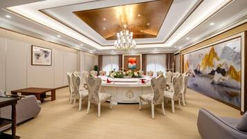 A dining area with a round table, chairs, and a chandelier.