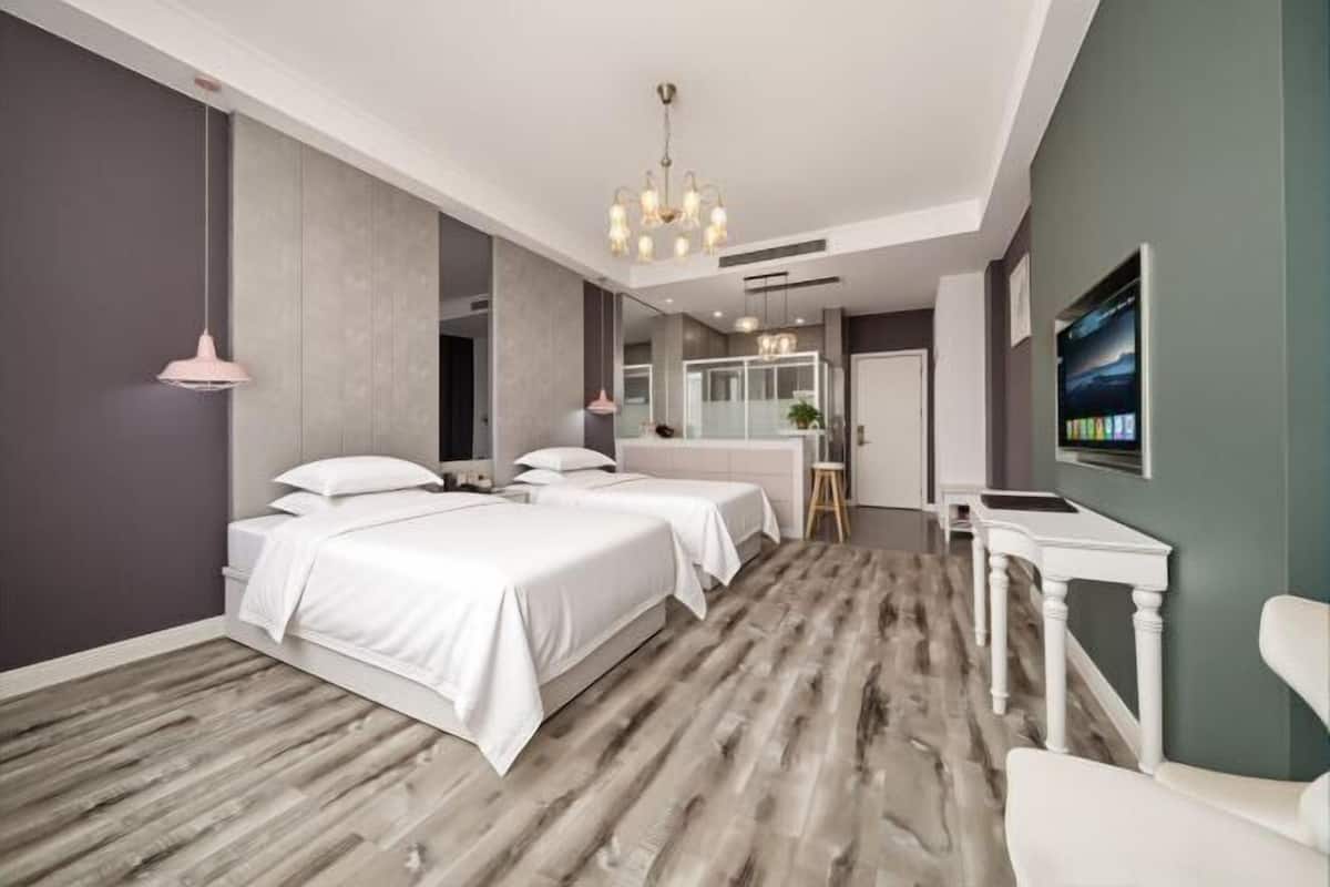 Une chambre d’hôtel moderne équipée d’un grand lit, d’un bureau, d’une chaise et d’un téléviseur.