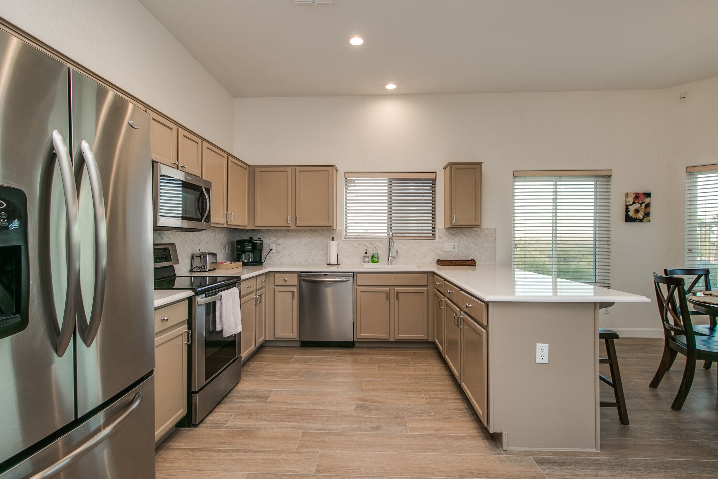 A modern kitchen with stainless steel appliances, wooden cabinets, and a central island.