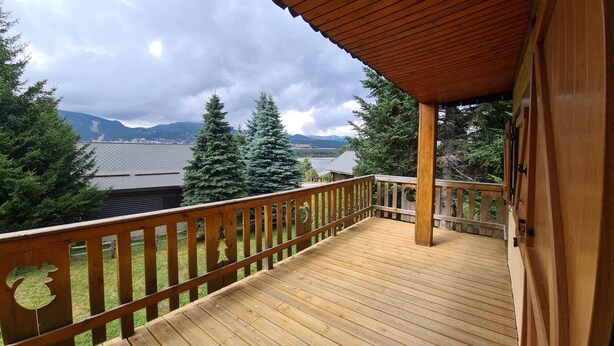 A wooden deck with a railing overlooking a mountainous landscape. - Lake view chalet (Matemale)
