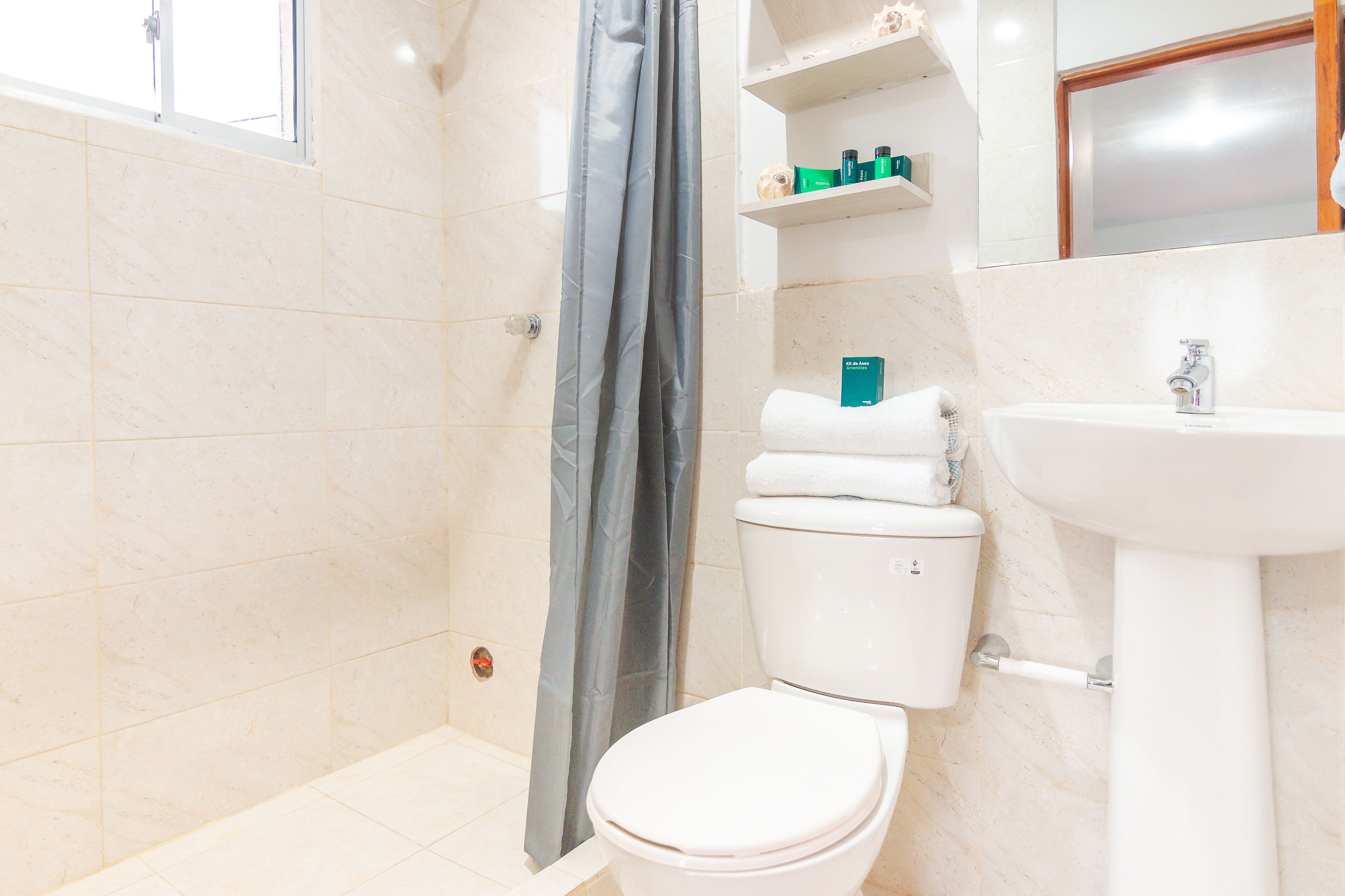 A bathroom with a toilet, sink, and shower curtain.