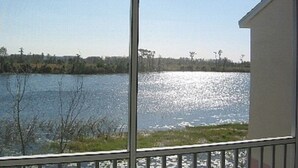Blick auf einen See von einem überdachten Balkon mit Geländer.