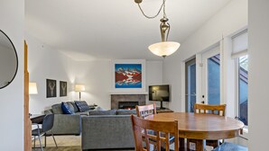 Una sala moderna con chimenea, una mesa de comedor con sillas y un sofá.